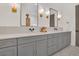 Double vanity bathroom with gray cabinetry, light countertops, and elegant gold fixtures at 15198 E Oakland Ave, Winter Garden, FL 34787