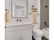 Bathroom with white vanity, black hardware, quartz countertop, decorative mirror, and shower with gray tile at 15198 E Oakland Ave, Winter Garden, FL 34787