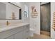 Modern bathroom featuring a grey vanity, gold hardware, decorative mirror and tiled shower at 15198 E Oakland Ave, Winter Garden, FL 34787