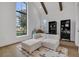 Bedroom with vaulted ceilings, exposed beams, large windows, and light wood floors, with a seating area at 15198 E Oakland Ave, Winter Garden, FL 34787