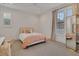 Bright bedroom with a cozy bed, neutral colored bedding, and a decorative full-length mirror at 15198 E Oakland Ave, Winter Garden, FL 34787