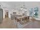 Bright dining room with modern light fixture and view into white kitchen with large center island at 15198 E Oakland Ave, Winter Garden, FL 34787