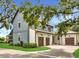 Side view of home with blue and white siding, brick driveway, and two car garage with dark wood doors at 15198 E Oakland Ave, Winter Garden, FL 34787