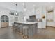 Bright kitchen with white cabinets, gray center island with seating, light wood floors, and stainless steel appliances at 15198 E Oakland Ave, Winter Garden, FL 34787