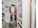 Spacious walk-in closet featuring built-in shelving, hanging rods, and an ottoman at 15198 E Oakland Ave, Winter Garden, FL 34787