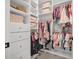 A walk-in closet with white organizers is complete with shelves and hanging rods for plenty of storage at 15198 E Oakland Ave, Winter Garden, FL 34787