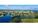 Aerial view of a community with homes and lakes connected by bridges under a partly cloudy sky at 15510 Lake Burnett Shore Ct, Winter Garden, FL 34787