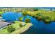 Aerial view of the property and lake showing the screened in pool area and lush landscaping at 15510 Lake Burnett Shore Ct, Winter Garden, FL 34787