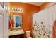 Cozy bathroom with floral shower curtain, single sink, and access to another room at 15510 Lake Burnett Shore Ct, Winter Garden, FL 34787