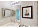 Elegant bathroom with decorative pictures, a large mirror, and a stone countertop at 15510 Lake Burnett Shore Ct, Winter Garden, FL 34787