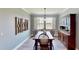 Bright dining room with dark wood table, matching chairs, a display hutch, and view of the lake at 15510 Lake Burnett Shore Ct, Winter Garden, FL 34787