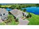 Stunning exterior view of home featuring a brick driveway, lush landscaping, and beautiful waterfront views at 15510 Lake Burnett Shore Ct, Winter Garden, FL 34787