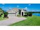 Attractive home with brick driveway, well-manicured lawn and landscaping, and a scenic waterfront view at 15510 Lake Burnett Shore Ct, Winter Garden, FL 34787