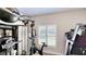 Home gym with treadmill, stationary bike, and weight-lifting equipment in front of a shuttered window at 15510 Lake Burnett Shore Ct, Winter Garden, FL 34787