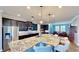 Open-concept kitchen features a large granite island, dark wood cabinets, and stainless steel appliances at 15510 Lake Burnett Shore Ct, Winter Garden, FL 34787