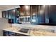 Close-up of kitchen showcases stainless steel microwave and cooktop complemented by granite countertops and cabinetry at 15510 Lake Burnett Shore Ct, Winter Garden, FL 34787