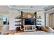 Inviting living room featuring stone accent wall, floating shelves, and lots of natural light at 15510 Lake Burnett Shore Ct, Winter Garden, FL 34787