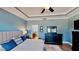 Bright main bedroom features blue walls, tray ceiling, and dark furniture with a view to the main bathroom at 15510 Lake Burnett Shore Ct, Winter Garden, FL 34787