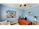 Bright office space with blue walls, wood desk, white shelves, and decorative displays at 15510 Lake Burnett Shore Ct, Winter Garden, FL 34787