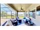 A covered patio is decorated with a ceiling fan, wicker furniture, and overlooks a serene lake view at 15510 Lake Burnett Shore Ct, Winter Garden, FL 34787