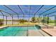 Beautiful pool and spa with a screen enclosure overlooking lush green grass and a lake at 15510 Lake Burnett Shore Ct, Winter Garden, FL 34787