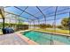 Pool and outdoor grill in a screened-in patio with picturesque lake views at 15510 Lake Burnett Shore Ct, Winter Garden, FL 34787