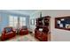 Bright seating area with 2 armchairs, and a wood hutch near the window with shutters at 15510 Lake Burnett Shore Ct, Winter Garden, FL 34787