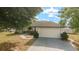 A home with a large driveway, two car garage and simple landscaping at 16190 Sw 16Th Ct, Ocala, FL 34473