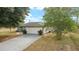 A home with a large driveway, two car garage and simple landscaping at 16190 Sw 16Th Ct, Ocala, FL 34473