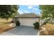 Two car garage with a paved driveway and well maintained landscaping at 16190 Sw 16Th Ct, Ocala, FL 34473