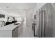 Modern kitchen with stainless steel appliances, white cabinets, and marble countertops open to the living room at 16190 Sw 16Th Ct, Ocala, FL 34473