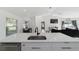 Modern kitchen island with a stainless steel sink, marble countertops, and views into the living room at 16190 Sw 16Th Ct, Ocala, FL 34473