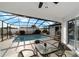 Outdoor living in the screened pool area is maximized with a dining set, lounge chairs, and a serene atmosphere at 16190 Sw 16Th Ct, Ocala, FL 34473