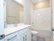 Bright bathroom with white tile, bathtub and shower combo with white sink and cabinets at 16489 Silver Brook Way, Winter Garden, FL 34787