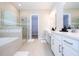 Bright bathroom with double vanities, a glass shower, and a separate tub at 16489 Silver Brook Way, Winter Garden, FL 34787