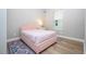 Bright bedroom features a cozy pink bed, side table, and large windows, creating a warm and inviting atmosphere at 16489 Silver Brook Way, Winter Garden, FL 34787