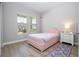 Cozy bedroom showcases a pink tufted bed, decorative rug, and bright windows for a welcoming ambiance at 16489 Silver Brook Way, Winter Garden, FL 34787