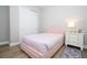Bedroom featuring a pink bed, hardwood floors and decorative rugs, with white nightstand at 16489 Silver Brook Way, Winter Garden, FL 34787