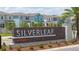 Silverleaf at Hamlin community entrance with colorful townhomes, professional landscaping, and stone-accented signage at 16489 Silver Brook Way, Winter Garden, FL 34787