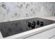 Modern electric cooktop with white and marble patterned backsplash at 16489 Silver Brook Way, Winter Garden, FL 34787