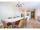 Open-concept dining room with decorative chandelier and modern table set at 16489 Silver Brook Way, Winter Garden, FL 34787