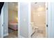 Hallway leading to bathroom with white cabinetry and bedroom with pink tufted headboard at 16489 Silver Brook Way, Winter Garden, FL 34787