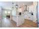 Spacious kitchen with stainless steel appliances, white cabinets, modern lighting and an island with a sink at 16489 Silver Brook Way, Winter Garden, FL 34787