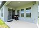 An outdoor patio featuring windows and a sliding glass door leading to a grassy backyard at 16489 Silver Brook Way, Winter Garden, FL 34787