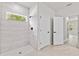 Walk-in shower with light tile and natural light from a small window at 17762 Sw 33Rd Ter, Ocala, FL 34473