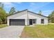 Modern home boasts a gray brick driveway, complemented by a black garage door and a clean, minimalist white exterior at 17762 Sw 33Rd Ter, Ocala, FL 34473