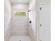 Walk-in shower with light tile and natural light from a small window at 17762 Sw 33Rd Ter, Ocala, FL 34473