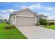Charming single-story home featuring manicured lawn, two car garage, and a side yard at 1805 Kingsmill Dr, Bartow, FL 33830