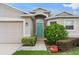 Inviting entryway with a turquoise-colored door, lush landscaping, and a cozy walkway at 1805 Kingsmill Dr, Bartow, FL 33830