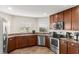 The kitchen features wood cabinetry, stainless steel appliances, and a tile floor at 1805 Kingsmill Dr, Bartow, FL 33830